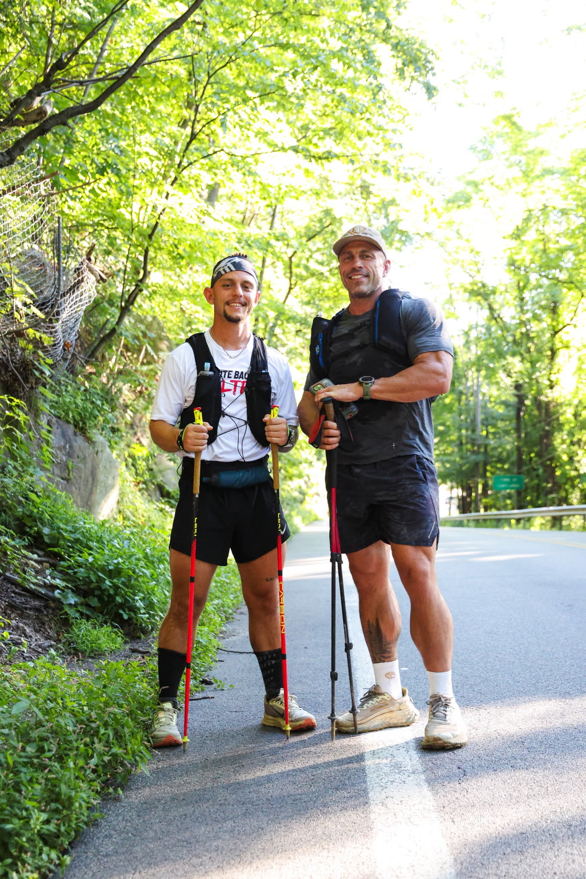 Two athletes with trekking poles and hydration packs outdoors