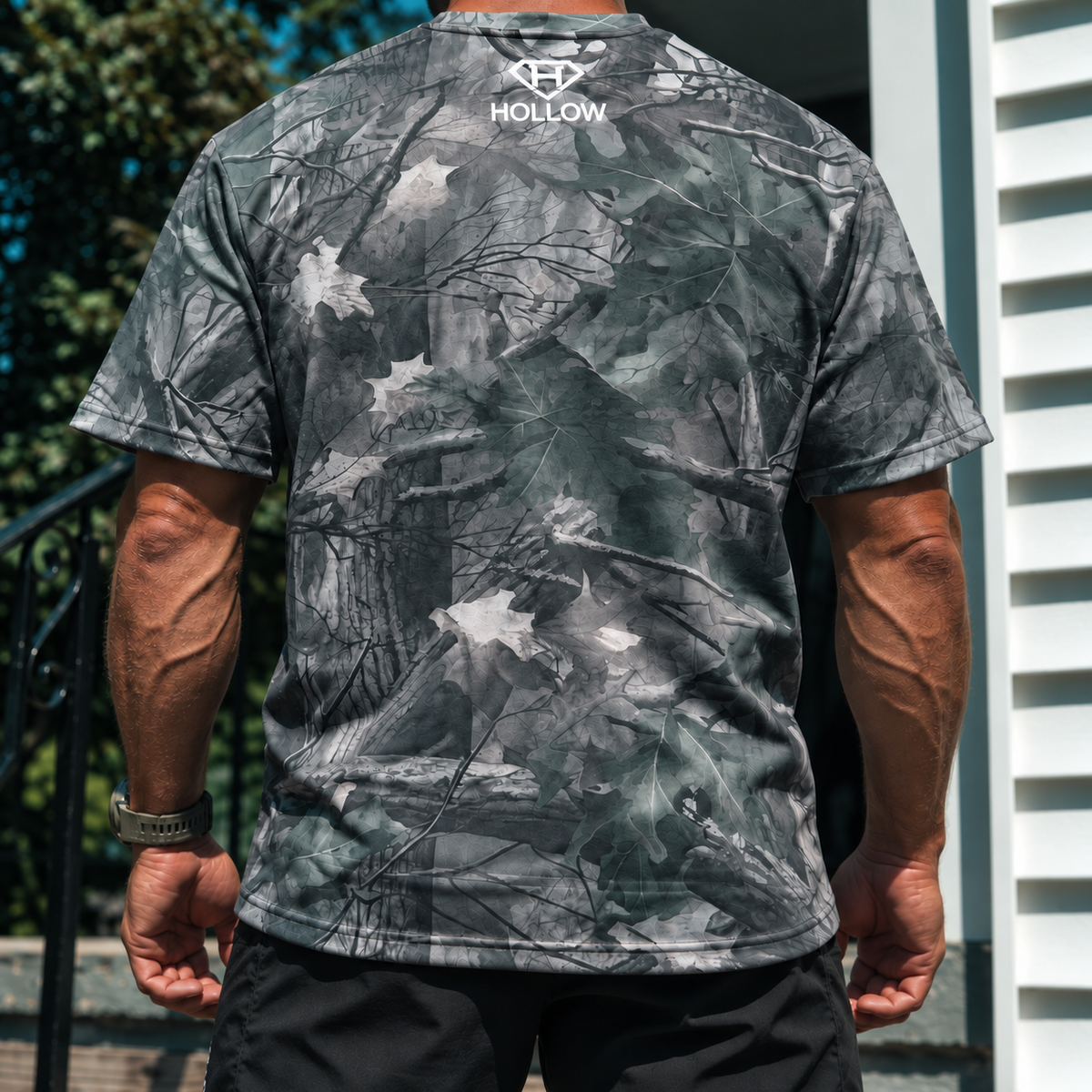 Cropped back view of Hollow woodland camo tee showing the upper-back logo and shirt fit