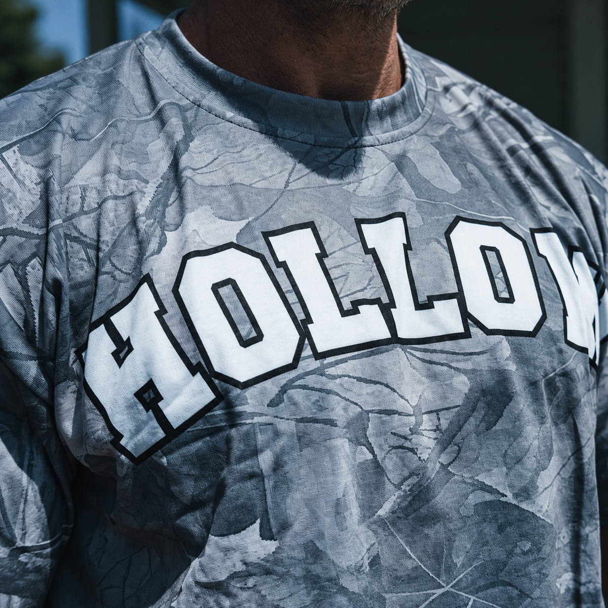 Enhanced closeup of white collegiate HOLLOW lettering and gray woodland print