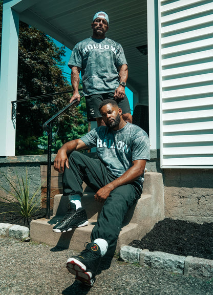 Two models wearing the Hollow woodland camo tee on outdoor steps
